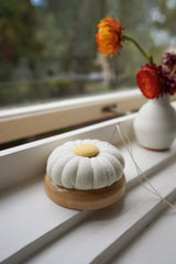 Flower pin cushion is displayed on a window sill
